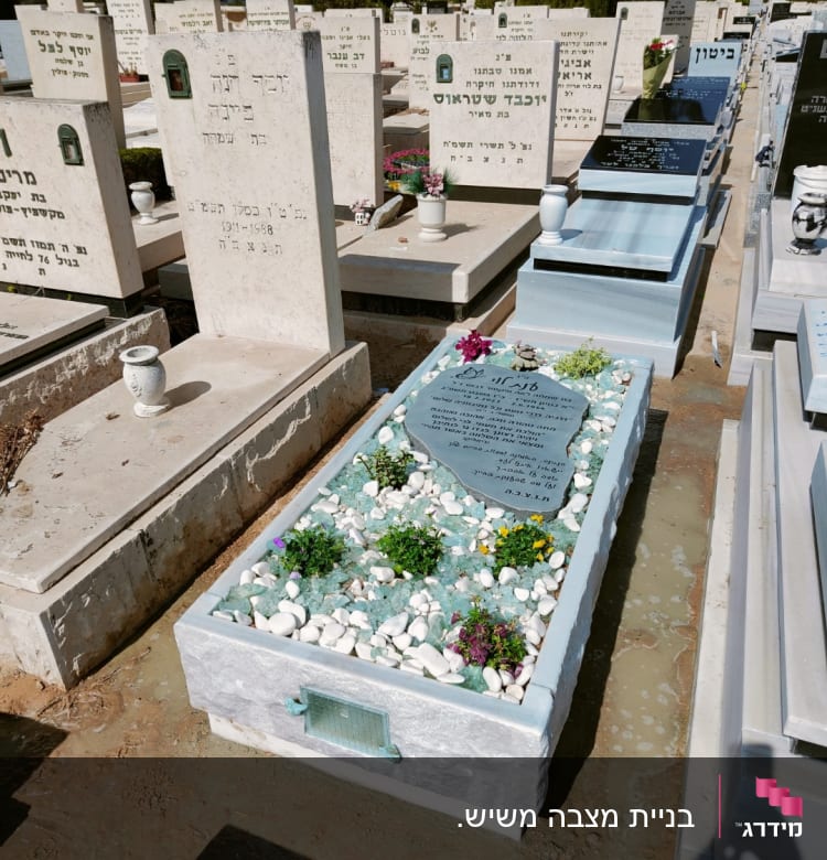 מצבות בבית קברות עם פרחים ואבנים